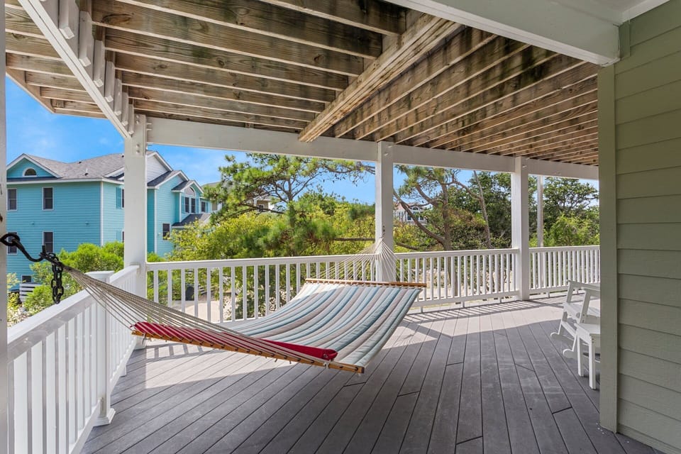 A large covered deck provides a shaded spot to unwind on the hammock with your favorite novel.