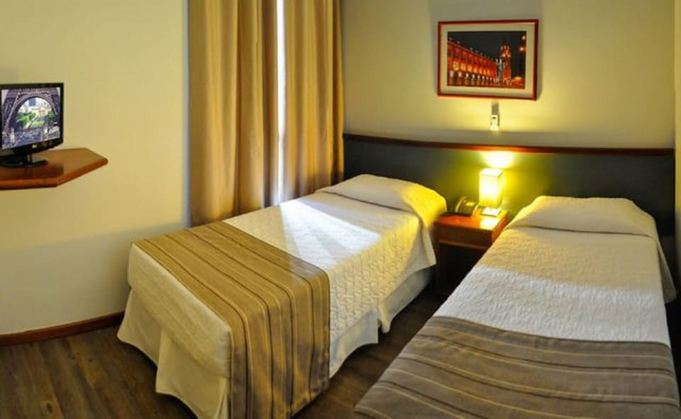 Apartamento 2 Camas Solteiro | Minibar, in-room safe, desk, blackout drapes
