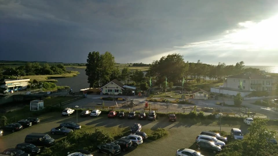 View from the balcony: stream and landscape in a mix of sun and clouds.