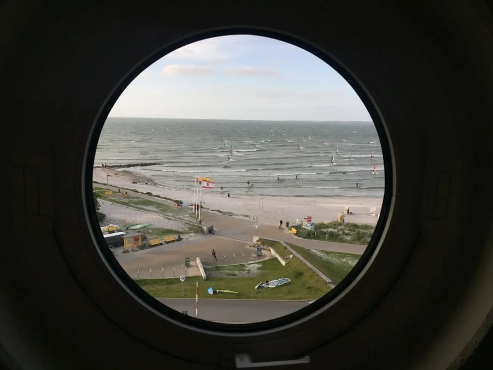 Kitchen - view through the round window of the beach and windsurfers
