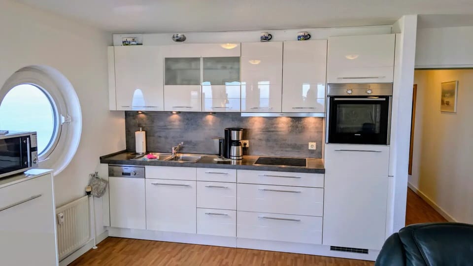 Modern kitchenette with round window and sea view - Living room