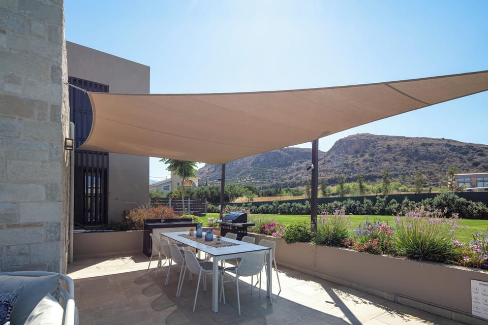 Enjoy an outdoor BBQ with a table seating 10 guests under a canopy