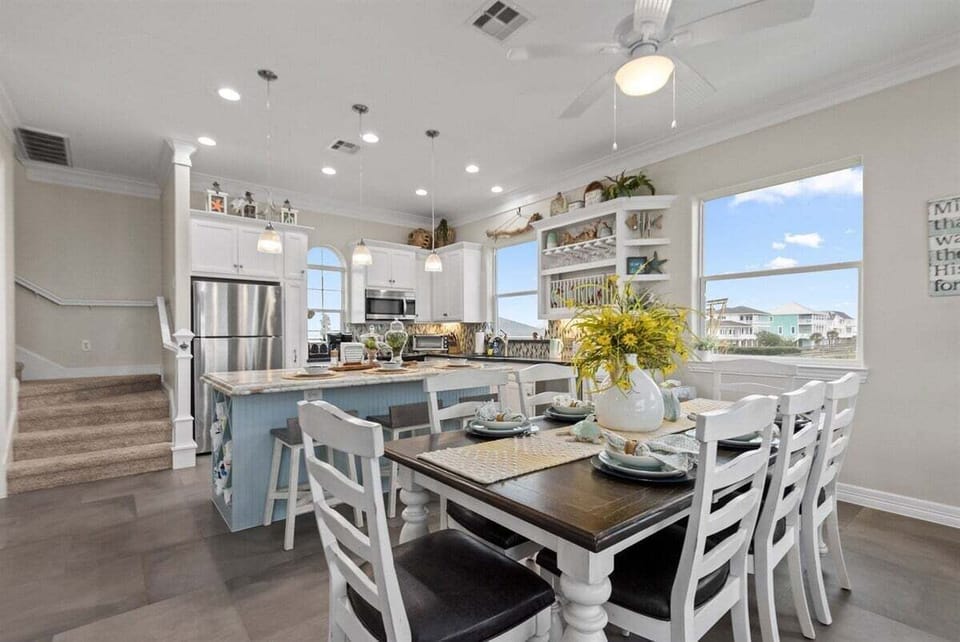 Open-concept dining area with seating for large groups and natural light from oversized windows.