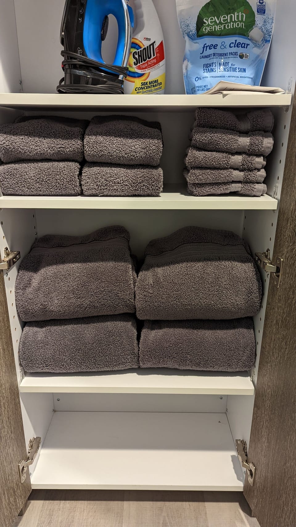 Iron & ironing board, laundry detergent & extra towels next to the washer/dryer