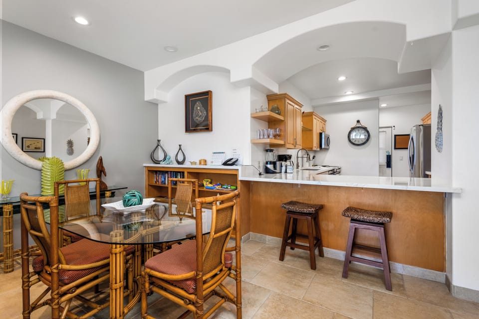 You'll love gathering around the glass dining table or relaxing at the breakfast bar, where warm wood cabinetry and modern appliances meet bright, open living. Inviting arches and thoughtful décor make it easy to feel at home.