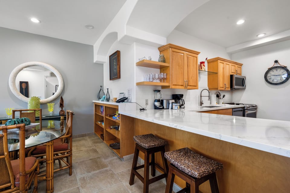 Step into your spacious, fully-equipped kitchen with a breakfast bar, perfect for sipping morning coffee or preparing meals while chatting with loved ones in the adjacent dining area.