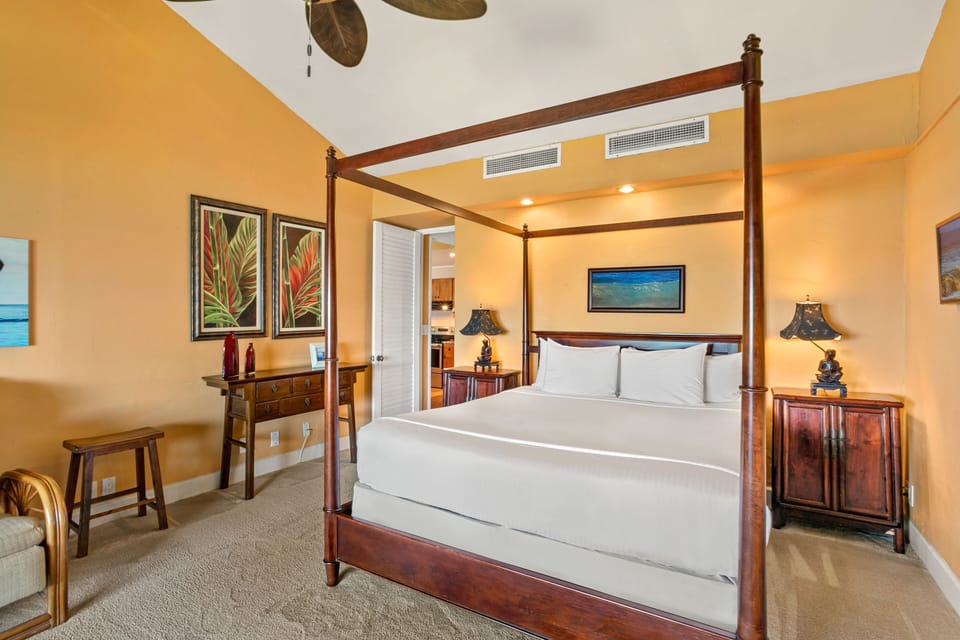 Sink into crisp white linens on your elegant four-poster bed, surrounded by warm tropical tones and island-inspired art that sets the perfect tone for your getaway.