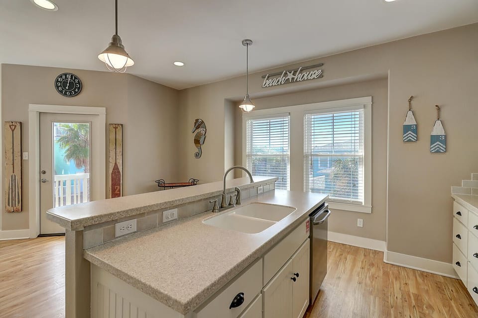 Your coastal-inspired kitchen features granite counters, modern appliances, and charming beach decor—perfect for preparing meals while enjoying natural light.