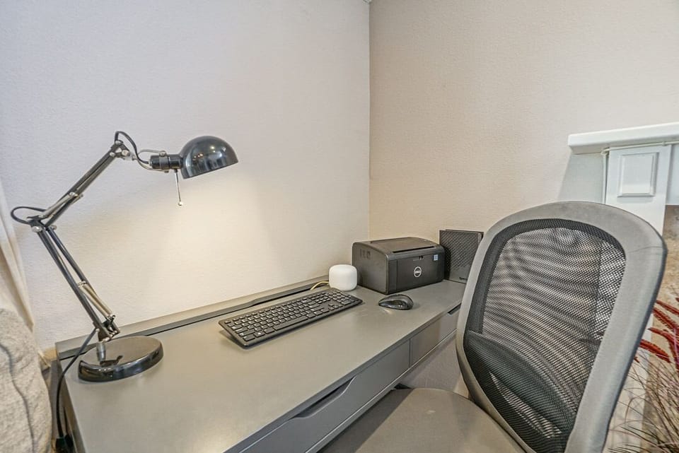 - Quiet workspace with desk chair and lamp for remote tasks   - Printer and essentials included for working convenience   - Perfect home office corner for business or vacation work