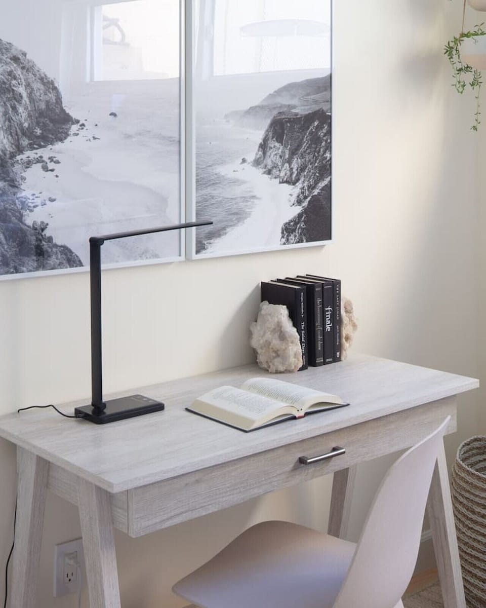 The calming, minimalist guest bedroom has a workspace and its own closet.