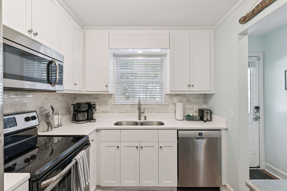 Your bright, fully equipped kitchen awaits, featuring modern appliances and ample counter space for preparing your favorite meals during your stay.