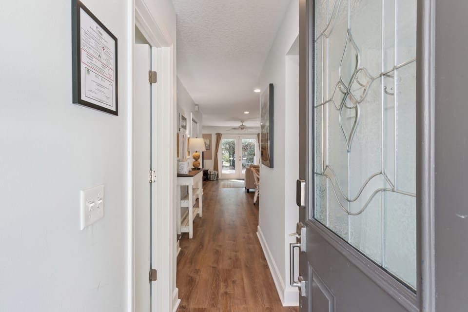 A welcoming entrance opens to bright, airy living spaces perfect for your stay. Warm wood floors guide you through this thoughtfully designed home filled with natural light and comfortable gathering areas.