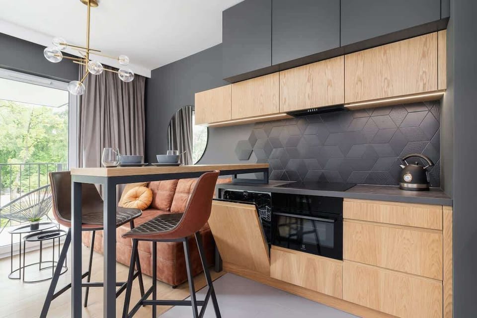 A modern kitchen with high-quality appliances and a kitchen island with chairs is perfect for preparing your favourite meals.
