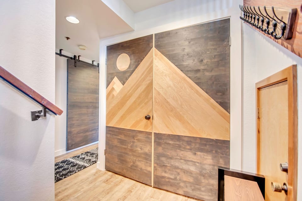 Custom mountain double door made by a local artisan hides the washer & dryer