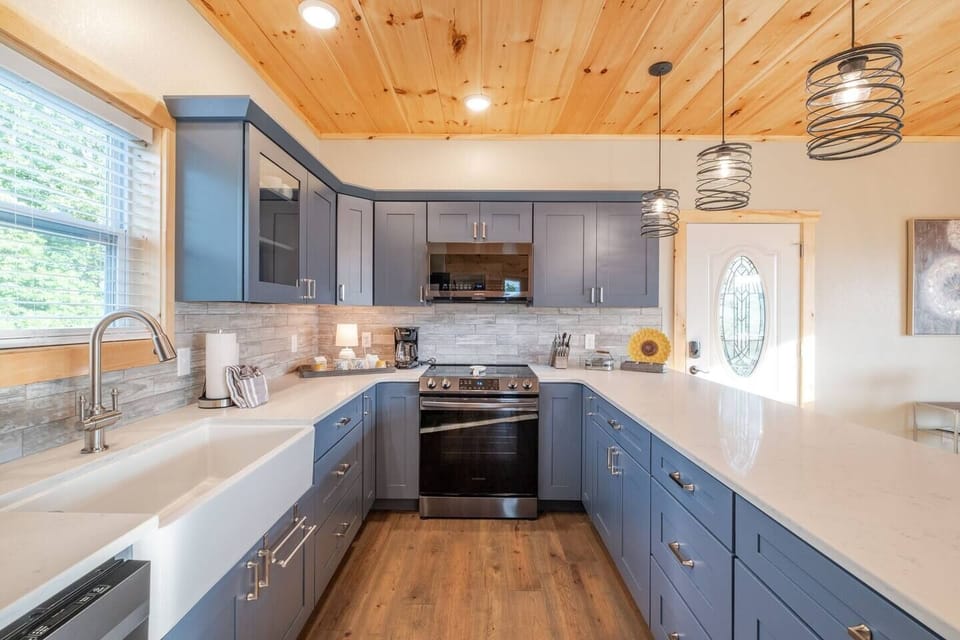 Beautiful kitchen with a large farm sink, quartz counter tops, and Kraftmaid cabinets