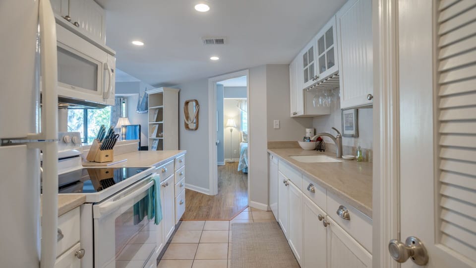 Glass-front upper cabinets add character, while modern appliances and a full suite of cookware make meal prep easy.