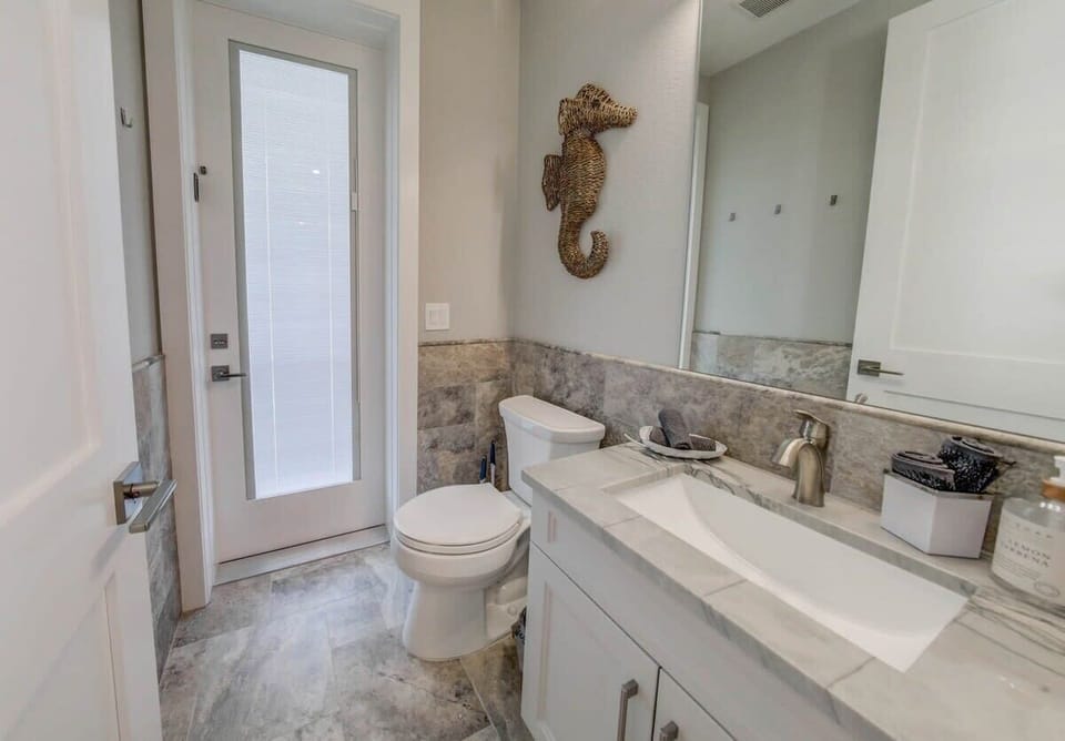 Half Bathroom • First Floor — Conveniently located between the first-floor living area and the pool for easy access during pool days.