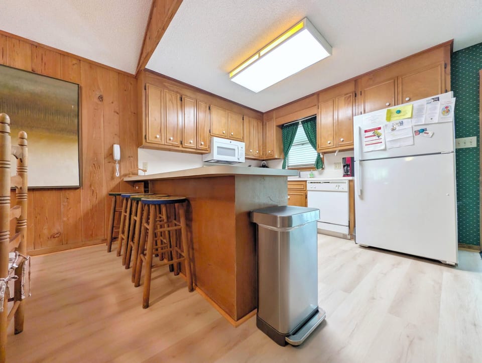 Your fully equipped kitchen features warm wood cabinetry, modern appliances, and a convenient breakfast bar—perfect for preparing home-cooked meals during your stay.