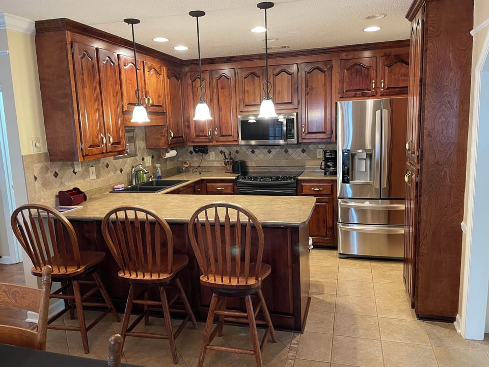 Full Size, fully stocked kitchen with three stool bar top. 
