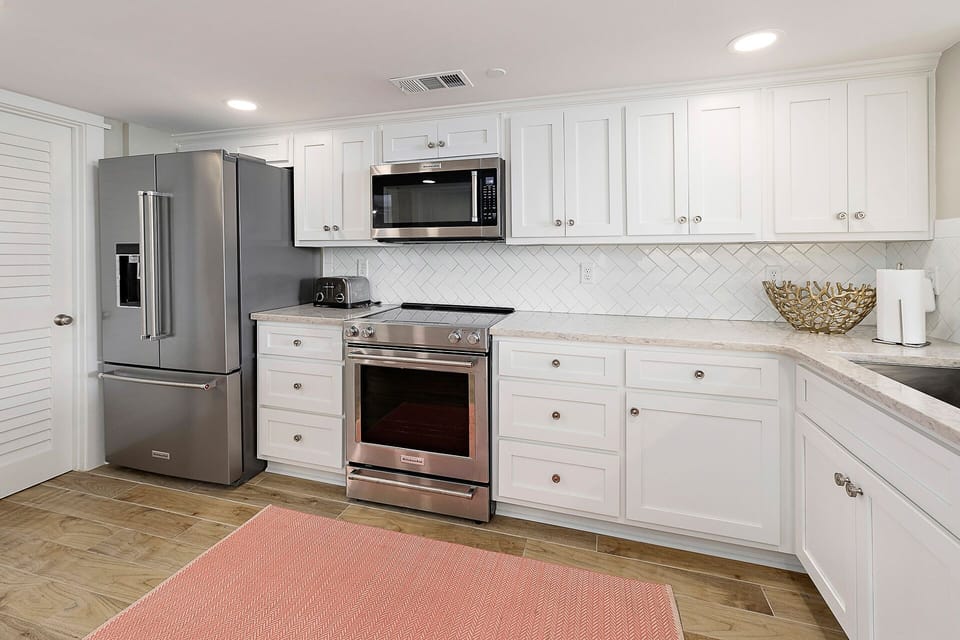 Spacious Kitchen features stainless steel appliances and new white cabinets