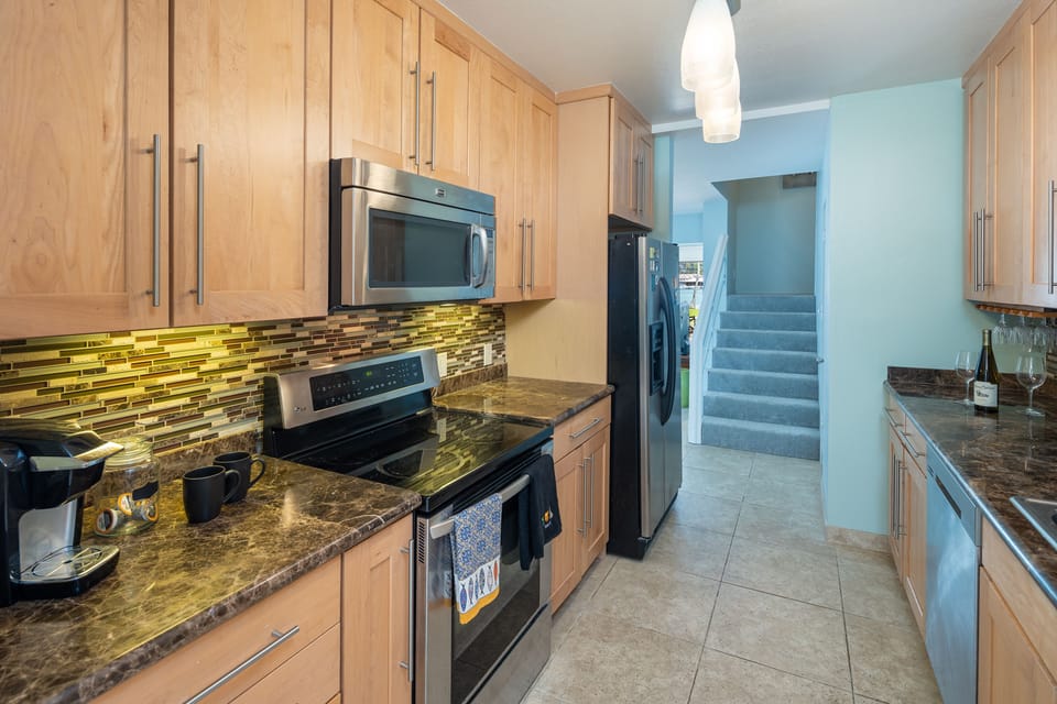 Kitchen with range/oven, microwave, Keurig coffee machine, cookwares, utensils