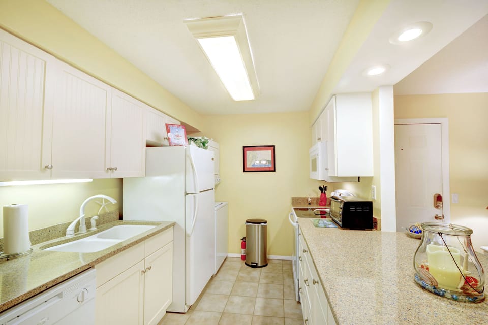 Bright Galley Kitchen – Full Setup at Ocean Walk W-14 - Whip up shrimp tacos or just pour the coffee—this fully equipped galley kitchen keeps it easy, whether you're feeding the crew or flying solo with leftovers.