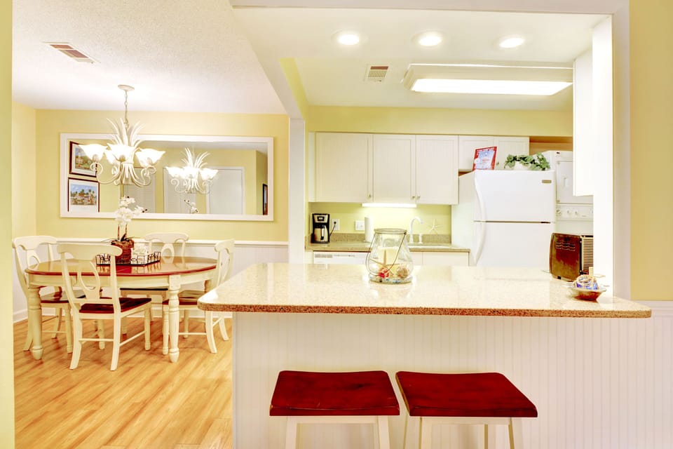 St. Simons Vacation Rental Kitchen + Dining – Ocean Walk W-14 - Bright and open, this full kitchen and dining area is made for shrimp boils, family meals, or lazy breakfasts that stretch past noon. Dining table seats six, with room for more at the bar.