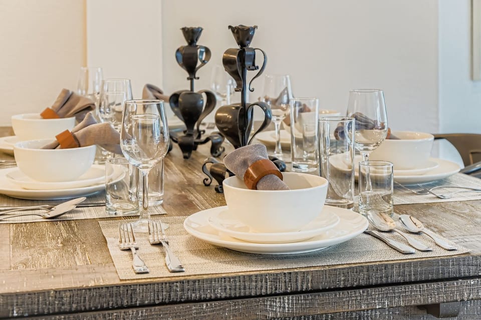 Your elegant dining space awaits with beautifully set table, fine glassware, and stylish candlesticks for memorable meals together.
