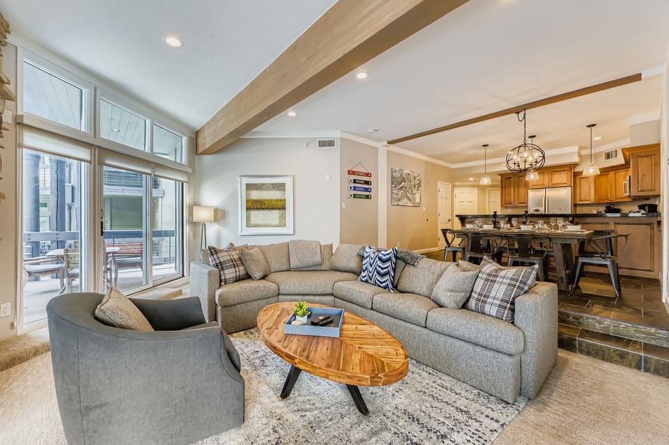 Relax in your spacious living area featuring a comfortable sectional sofa, stylish coffee table, and an open-concept layout that flows seamlessly into the fully equipped kitchen.