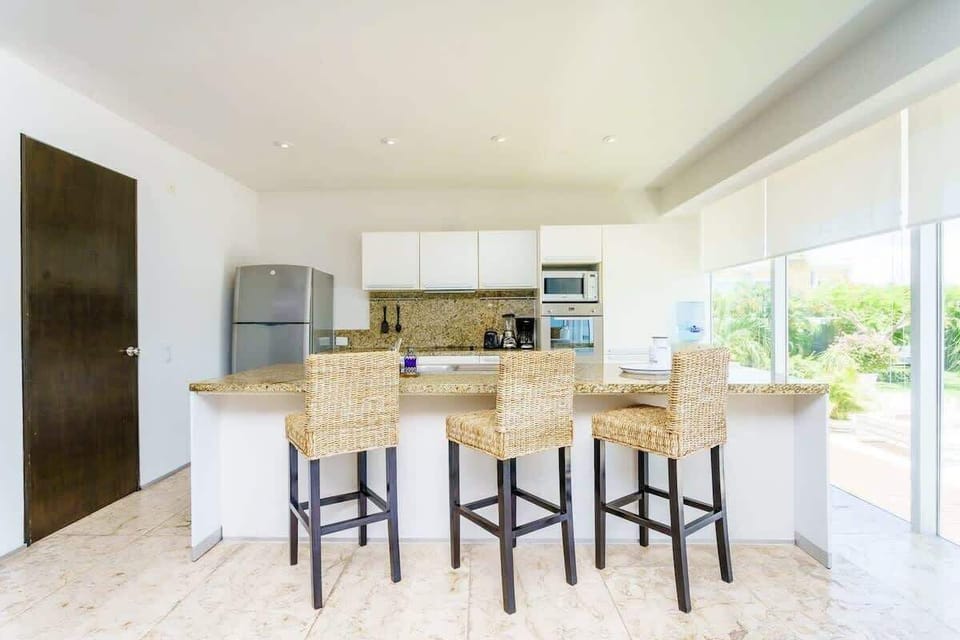 Beautiful natural light illuminates the breakfast bar kitchen space