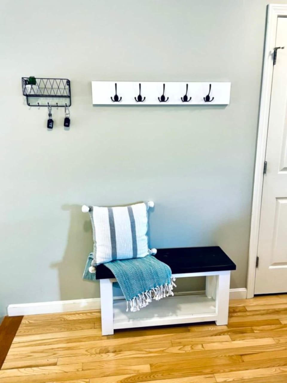A convenient drop zone in the foyer, complete with bench, coat hooks, key hooks
