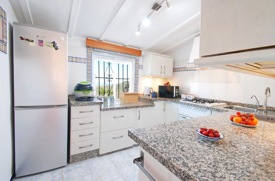 Our kitchen is well equipped and has view to the garden.