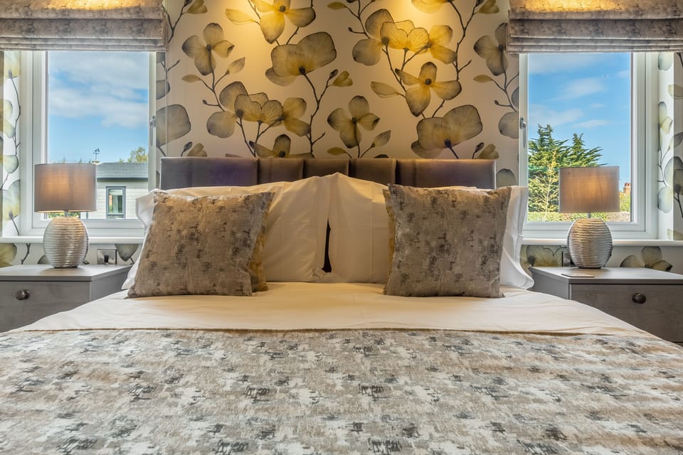 Pretty feature wallpaper in the master bedroom with king-size bed