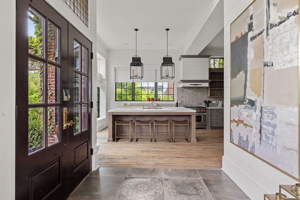 Enjoy a wide array of seating options for meals including these 4 chic stools at the white marble island.