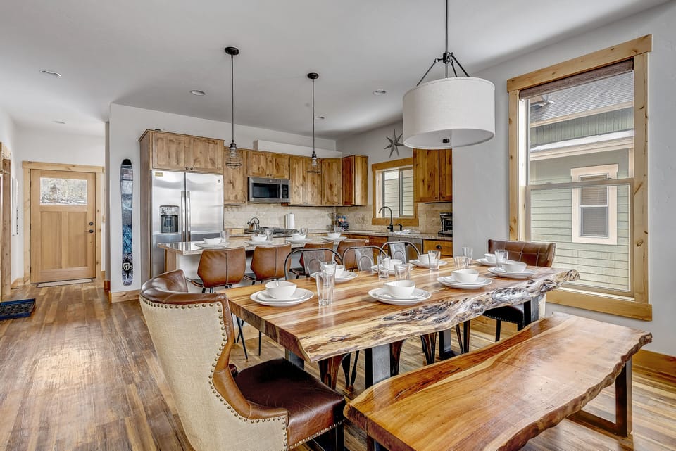 - Spacious dining area with live edge wooden table and stylish seating   - Open concept layout flows into modern kitchen with wood accents   - Perfect cabin rental for group dining and Colorado gatherings