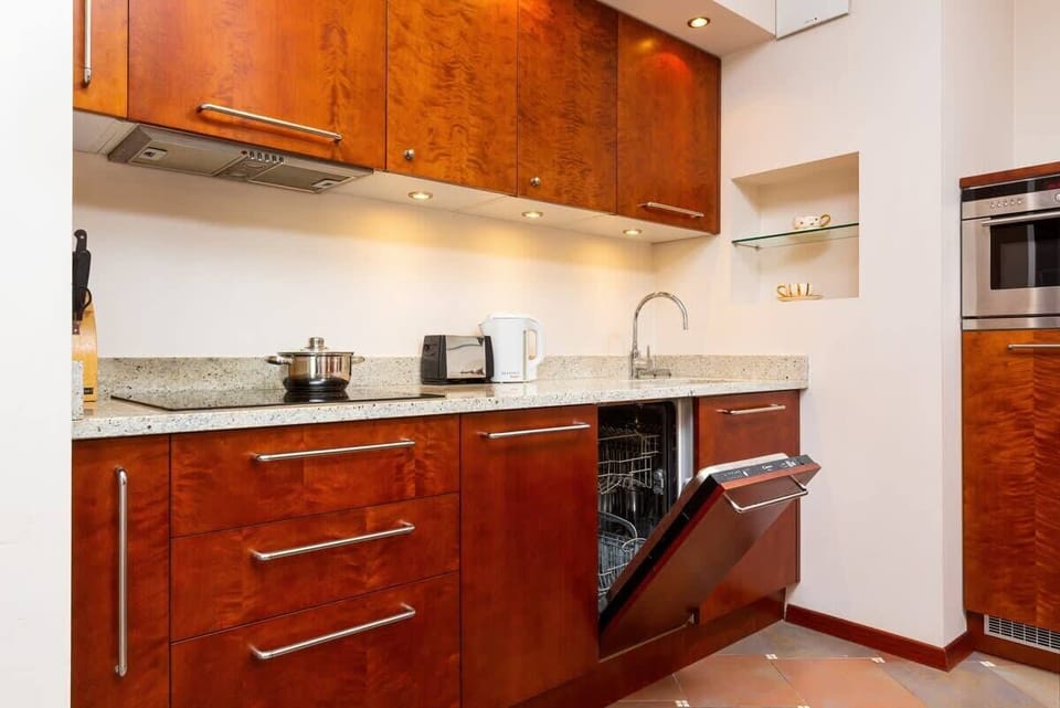 Kitchenette with kettle and refrigerator. 