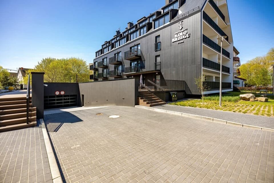 A contemporary apartment building surrounded by greenery, showcasing modern architecture.
