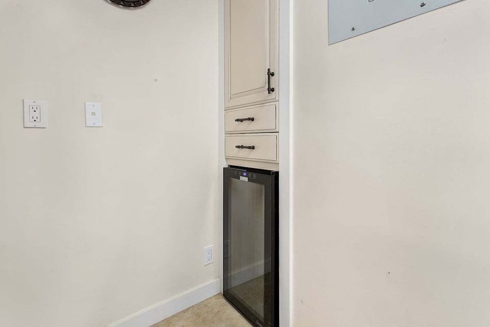 Compact kitchen space with mini refrigerator and cabinetry, simple design blending into the suite.