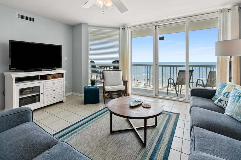 Sectional sofa facing sliding doors and the ocean at Paradise Pointe 4B, a 3-bedroom Cherry Grove rental
