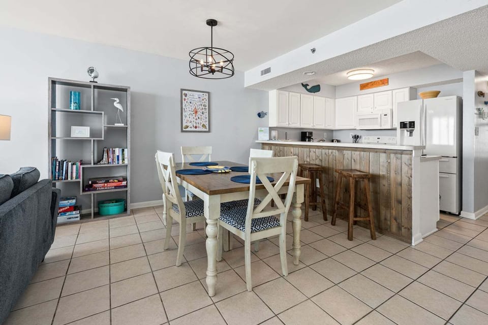 Dining table set beside a white kitchen at Paradise Pointe 4B in Cherry Grove, North Myrtle Beach