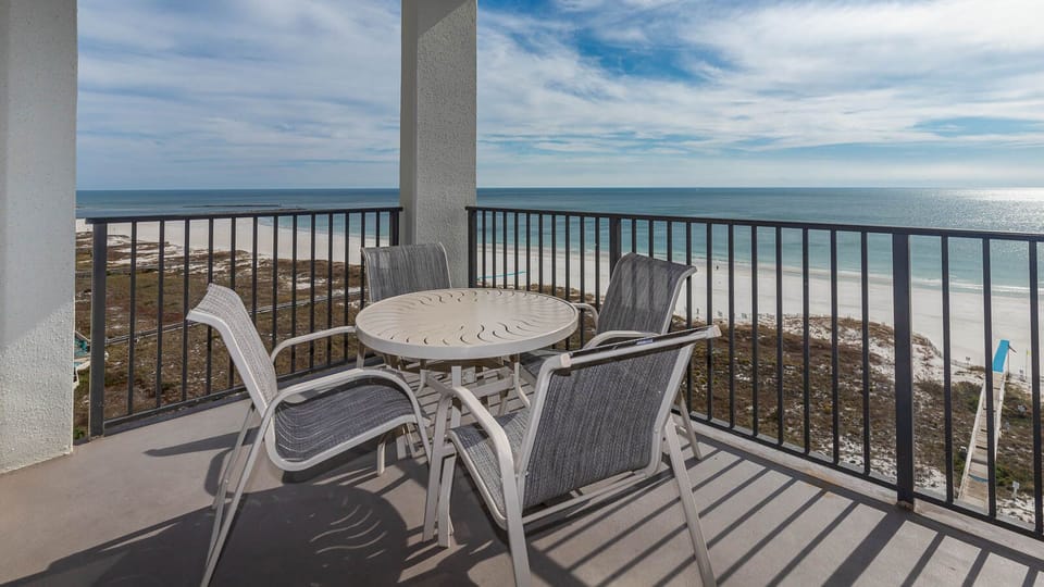 Balcony seating offers a relaxing spot to enjoy panoramic views of the tranquil gulf and white sand beach below