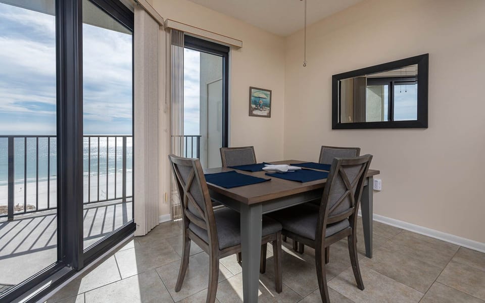 Dining area featuring a table with seating for four and a stunning view of the gulf through large sliding glass doors