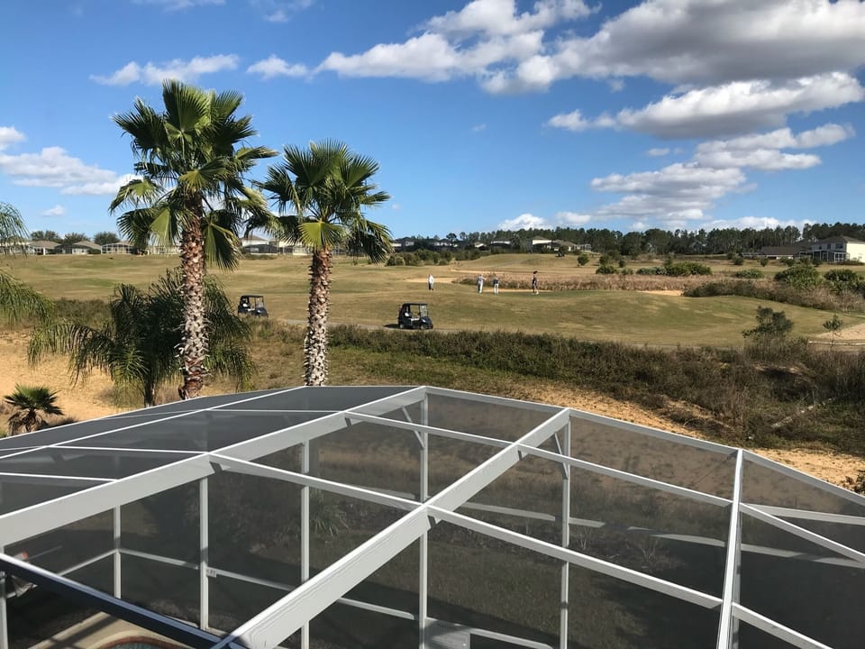Upstairs King bedroom view with picture window overlooking pool and golf course