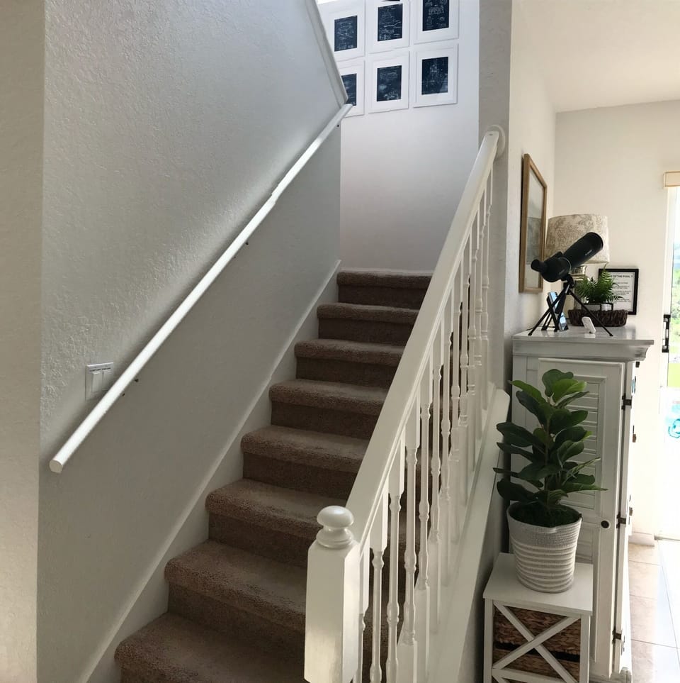 Staircase leading to carpeted four bedrooms and two baths