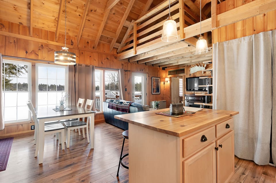 Kitchen offers an island with seating and cabinets fully stocked with cookware.