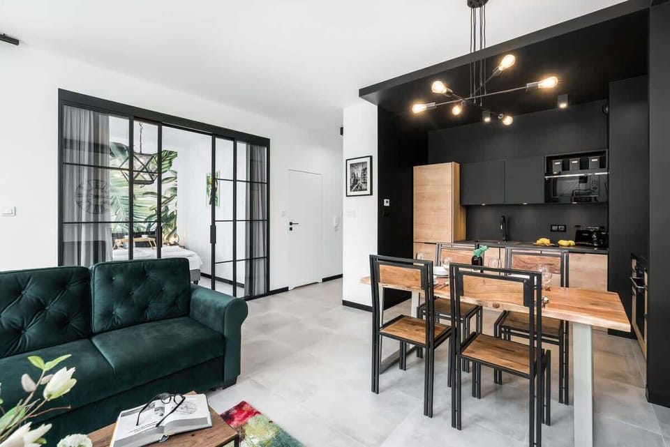 A spacious living room with an open design, featuring a dining area and floor-to-ceiling windows.