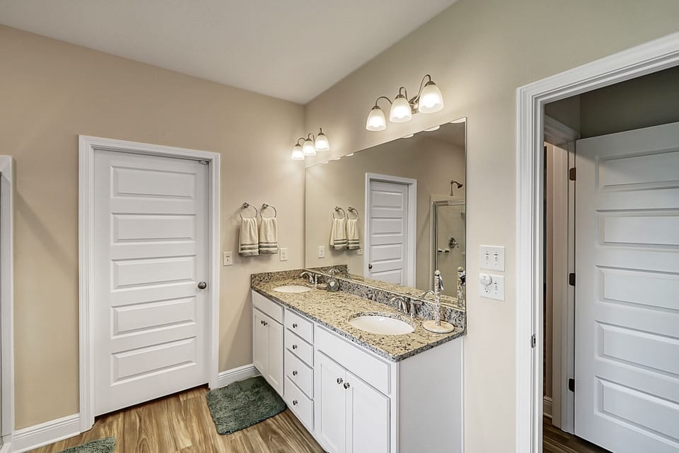 Attached bath with double vanities, soaking tub, walk-in shower, and private water closet