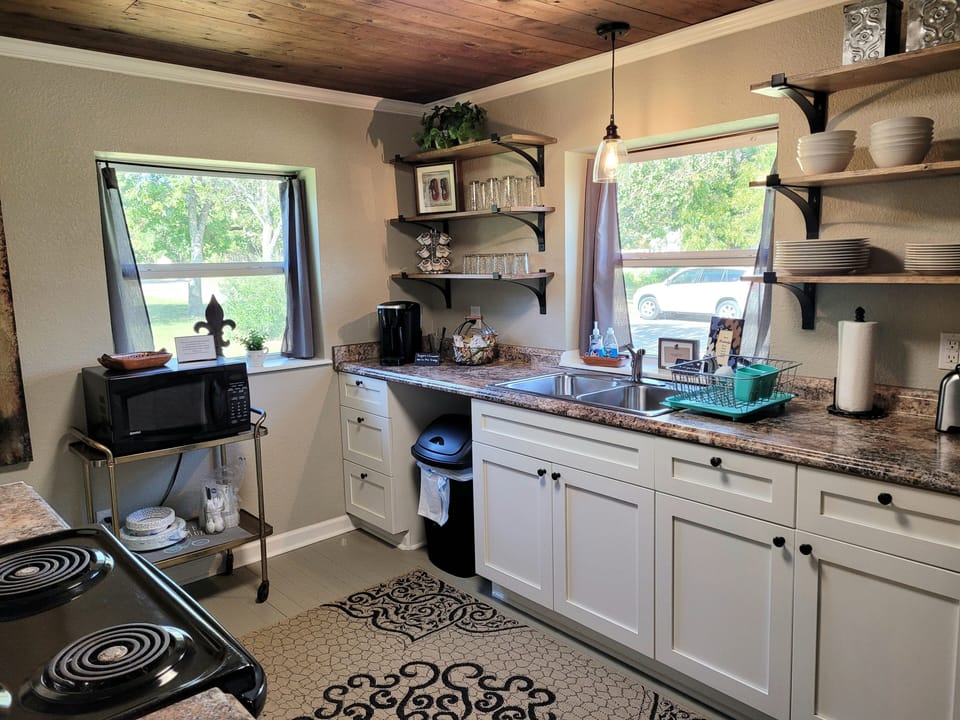 This kitchen is stocked with pots, pans, mixing bowls, cutlery, and dishes.
