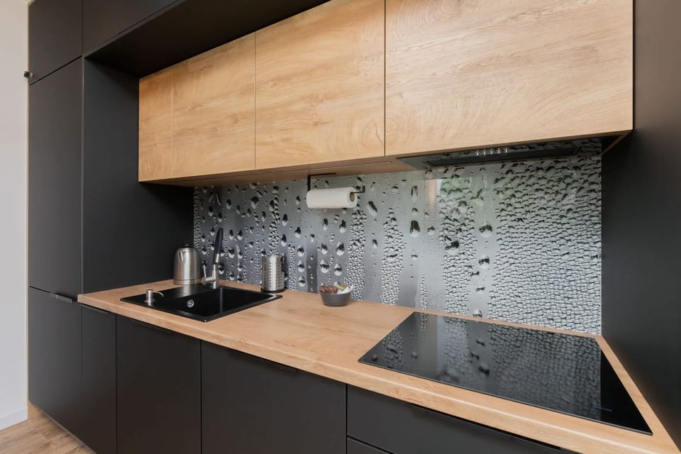 Well-equipped kitchen featuring modern black cabinetry, wooden countertops, and high-end appliances.