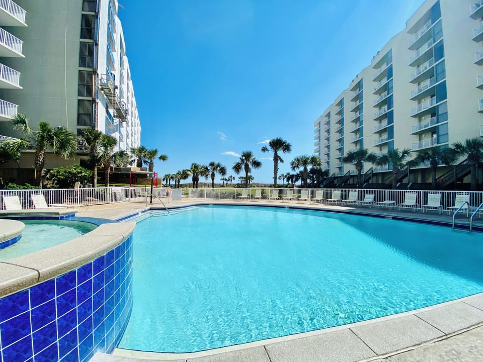 Crystal-clear pool surrounded by swaying palm trees creates the perfect tropical oasis for your vacation escape.